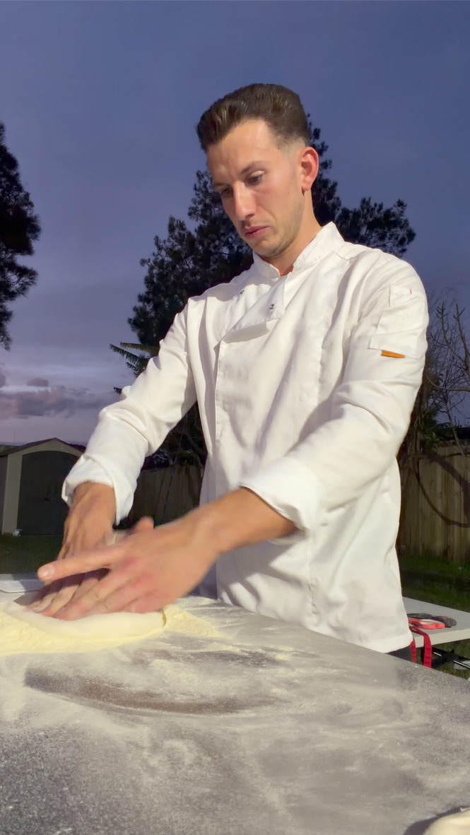 Matteo stretching pizza dough at dusk