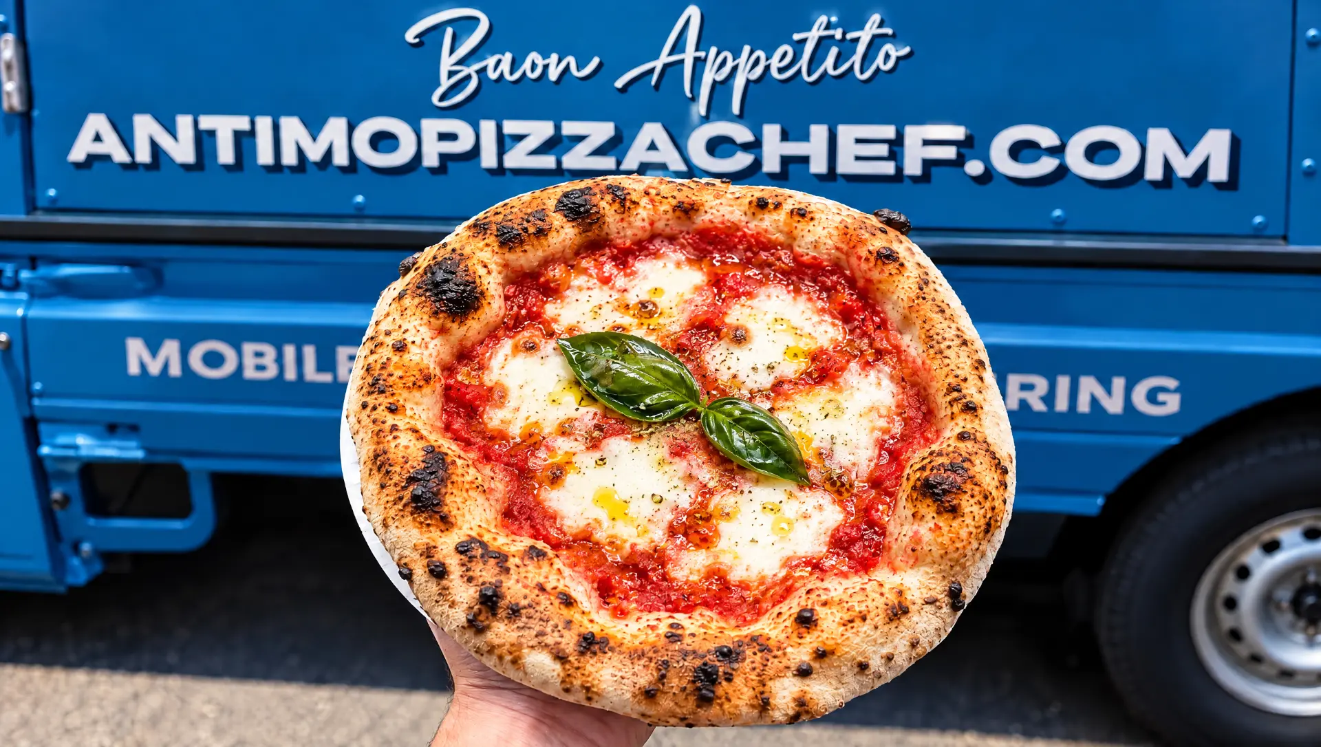 Fresh Neapolitan margherita pizza held up in front of the Antimo mobile pizza truck